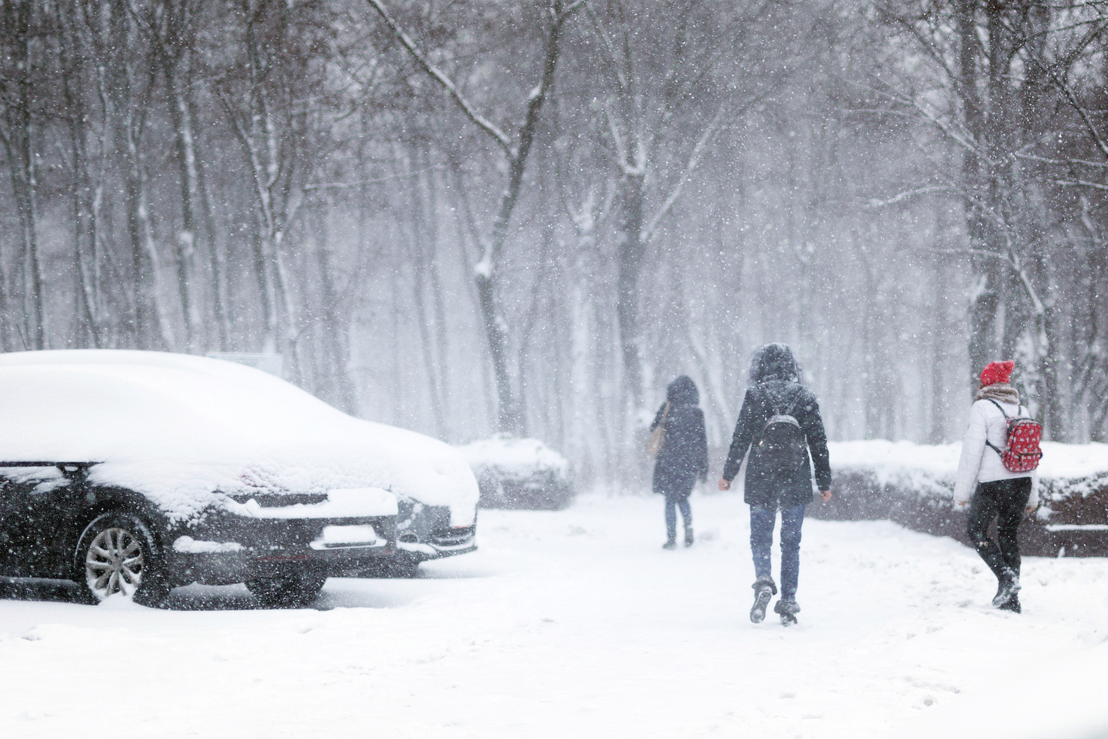 People Walking Through City Street Covered With Snow During Heav